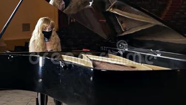 一个穿着黑色连衣裙，脸上戴着面具的女孩<strong>弹钢琴</strong>。 不寻常的音乐表演